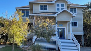 A two-story building with a front porch, a staircase, and a sign that reads "BRIGHTSIDE". - Escape to beautiful 4 BR home, Brightside OBX—Your Corolla Beach Retreat Awaits! (Corolla)