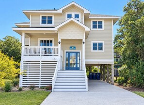 A two-story house with a front porch, a garage, and a small deck. - Escape to beautiful Brightside OBX-Your Corolla Outer Banks Beach Retreat Awaits (Corolla)