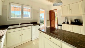 A kitchen with white cabinets, a granite countertop, a window with a view, and a ceiling light. - SEASIDE VILLA WITH POOL - PERFECT FOR FAMILY & FRIENDS (Saint-Raphaël)
