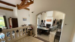 A spacious living area with a high ceiling, a dining table, and a fireplace. - SEASIDE VILLA WITH POOL - PERFECT FOR FAMILY & FRIENDS (Saint-Raphaël)