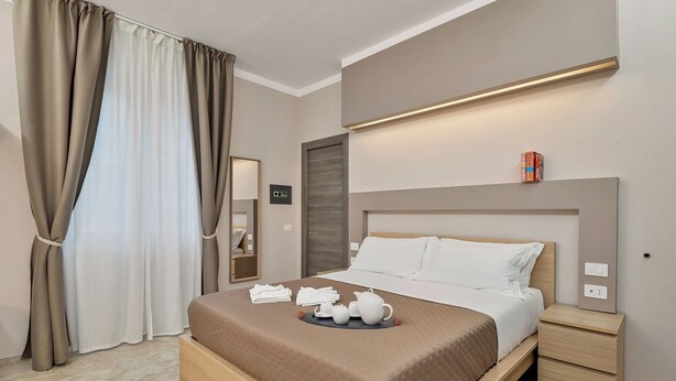 Une chambre d’hôtel avec un lit, une table de chevet et une petite table.