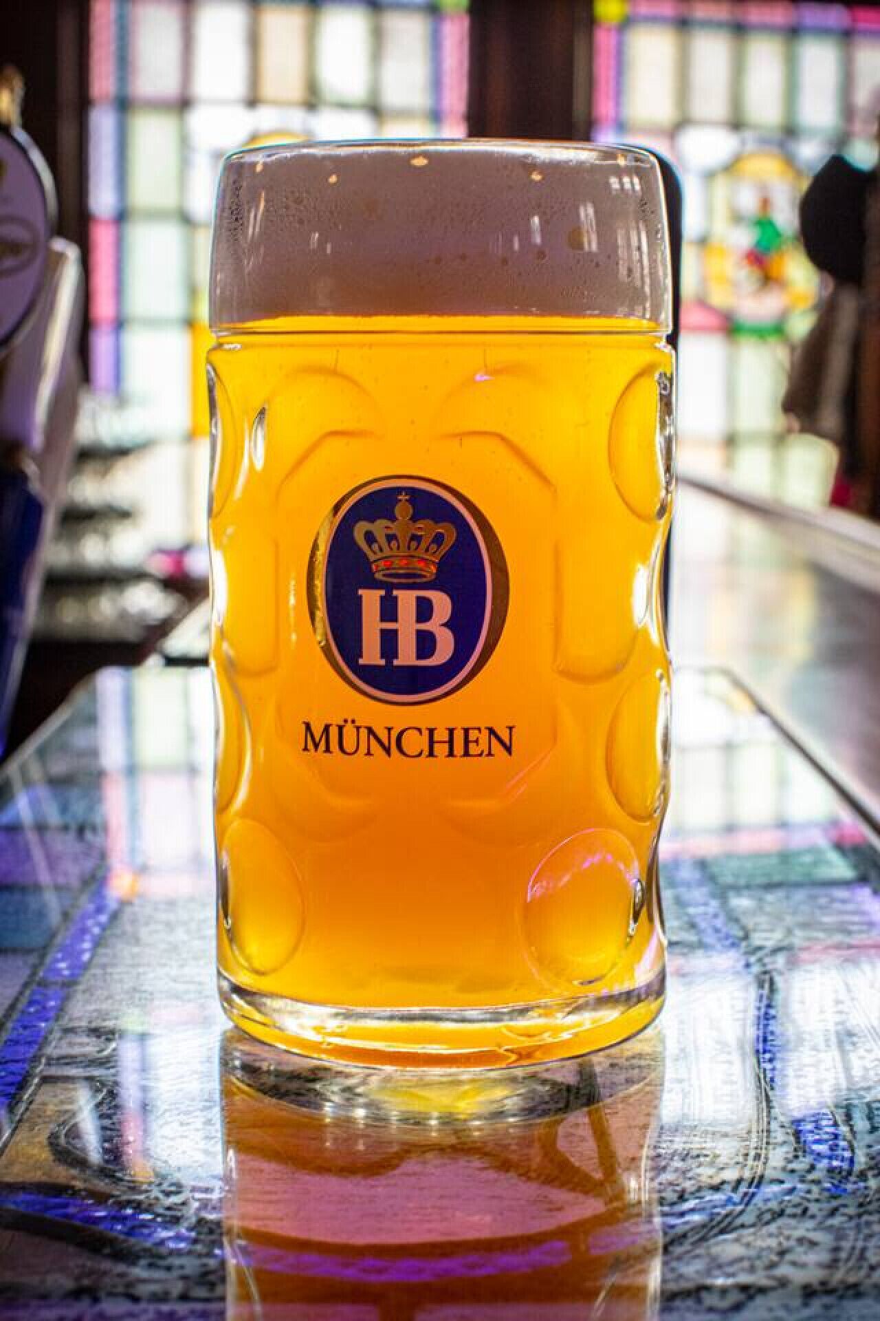 A glass of beer with a logo and the word "MÜNCHEN" on it.