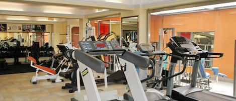 A gym with treadmills, weight machines, and exercise equipment.