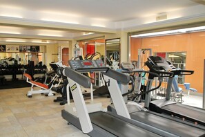 Ein Fitnessstudio mit Laufbändern, Kraftgeräten und Trainingsausrüstung.