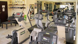 Ein Fitnessstudio mit Laufbändern, Crosstrainern und Krafttrainingsgeräten.