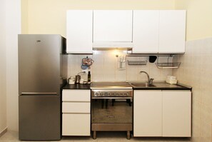 Eine kleine Küche mit Kühlschrank, Herd und Spüle.