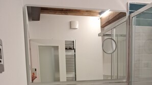 A bathroom with a dark wooden vanity, a green sink, and a mirror above it. - House Sant Angelo (Acquapendente)