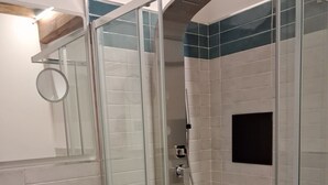 A bathroom with a glass-enclosed shower, a wooden vanity, and a tiled wall. - House Sant Angelo (Acquapendente)