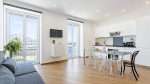 A modern apartment with a living room, dining area, and kitchen.