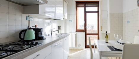 Kjøleskap, oppvaskmaskin og høy barnestol