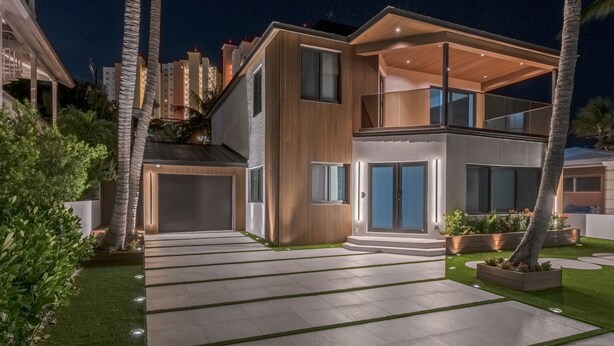 Ein modernes, zweistöckiges Haus mit großzügigem Auffahrt, Garage und gepflegtem Rasen.