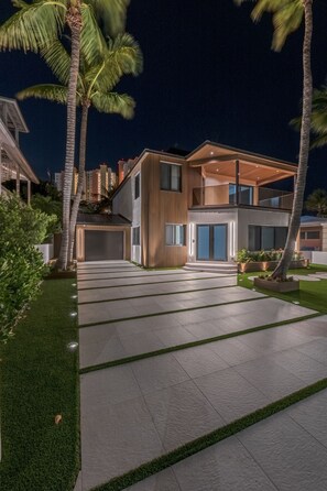 Une maison moderne à deux étages, dotée d’une allée spacieuse, d’un garage et d’une pelouse bien entretenue.