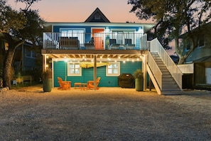 A two-story house with a covered patio area, a staircase, and outdoor seating. - Sand Dollar Suite (Fort Myers Beach)