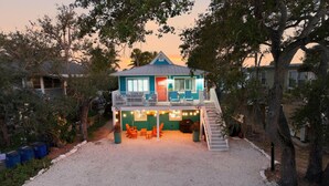 A two-story house with a porch, outdoor seating, and a barbecue area. - Coral Suite (Fort Myers Beach)