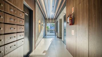A hallway with wooden lockers, a fire extinguisher, and a sign indicating a 'Seizure Room'.
