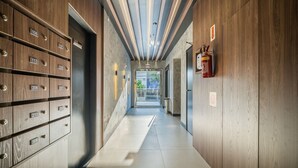 Un couloir avec des casiers en bois, un extincteur et un panneau indiquant une « salle de confinement ».