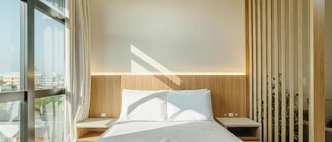 Un dormitorio moderno con una cama grande, vistas a la ciudad y una división de madera.