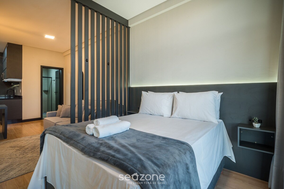 Een moderne hotelkamer met een groot bed, een bureau en een zithoek.