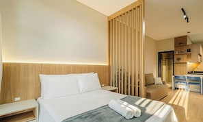 Une chambre d’hôtel équipée d’un lit, d’un bureau, d’une chaise et d’une kitchenette.