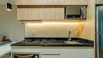 A kitchen with a built-in microwave, a sink, and a stove.
