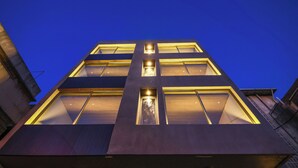 A modern building with a dark facade and illuminated windows at night. - Nice studio with AC in charming Broummana perfect for relaxing stays (Broummana)