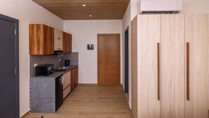A compact kitchen with wooden cabinets, a microwave, and a built-in oven. - Nice studio with AC in charming Broummana perfect for relaxing stays (Broummana)