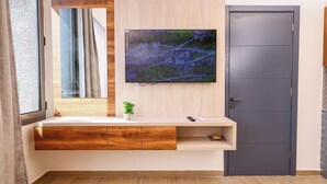 A modern bathroom with a wooden vanity, a mounted TV, and a door. - Nice studio with AC in charming Broummana perfect for relaxing stays (Broummana)
