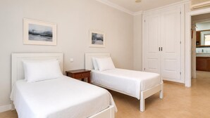 Ein Hotelzimmer mit zwei Betten, einem kleinen Nachttisch und einer Tür zum Badezimmer.