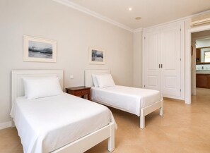 A hotel room with two beds, a small bedside table, and a door leading to a bathroom. - Villa Casa Faro - Four Bedroom Villa, Sleeps 8 (Mallorca)