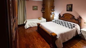 A bedroom with two single beds, a wooden wardrobe, a nightstand, and a ceiling light fixture. - Turquoise fairy family suite (Collodi)