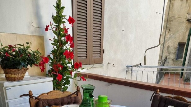 A table set for breakfast with various dishes, a pitcher of juice, and a vase of flowers. - Turquoise fairy family suite (Collodi)