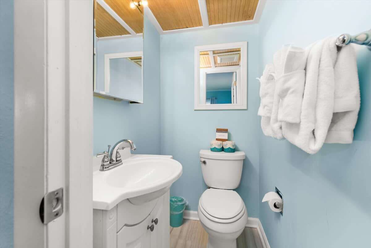 Un baño con lavamanos blanco, inodoro y barra para toallas.