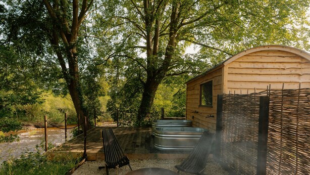 A rustic cabin with a fire pit, outdoor seating, and a small pool. - Dog friendly glamping accommodation with hot tub in Ripon, Yorkshire (West Tanfield - Ripon)