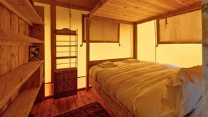 A wooden room with a bed, a shelf, a window, and a door. - Dog friendly glamping accommodation in Ripon, Yorkshire (West Tanfield - Ripon)