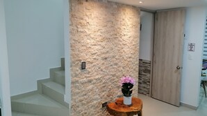A modern interior with a stone wall, a wooden door, and a staircase. - Near the main park of Salento (Salento)