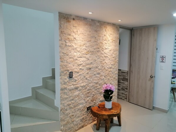 A modern interior with a stone wall, a wooden door, and a staircase. - Near the main park of Salento (Salento)