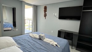 Una habitación de hotel moderna con una cama grande, un televisor de pantalla plana en la pared y un escritorio pequeño.