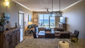A spacious living area with a dining table, a sofa, and a view of the ocean. - Ariel Dunes II 1609 (Miramar Beach)