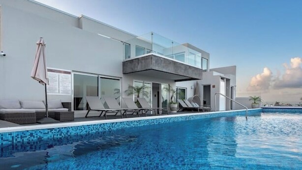 A modern hotel with a pool area, including lounge chairs and a glass balustrade. - Beautiful view and location, roof terrace with sea view! (Playa del Carmen)