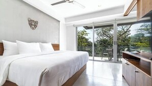 A bedroom with a large bed, a ceiling fan, a sliding glass door leading to an outdoor area, and a wooden cabinet. - Beautiful view and location, roof terrace with sea view! (Playa del Carmen)