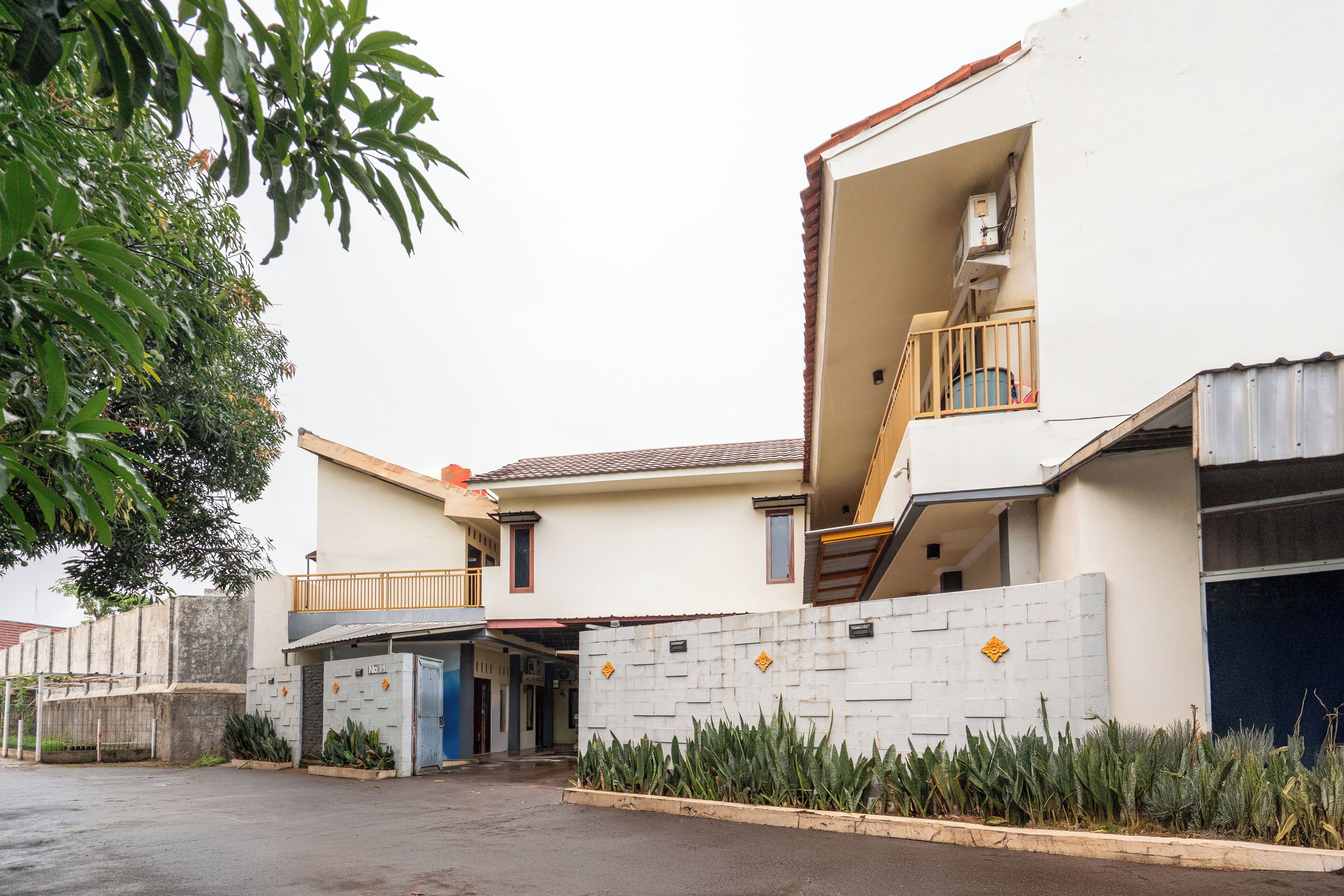 A two-story residential building with a balcony, a staircase, and a garage.