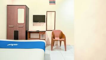A hotel room with a bed, a desk, a chair, a wardrobe, and a TV.