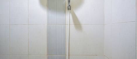 A shower with a handheld faucet in a tiled bathroom.