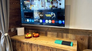 A flat-screen TV mounted on a wooden wall displaying a streaming service interface with various icons and a bulletin board with notes and a calendar. - Chalet de Solaise B03 (Val-d'Isère)