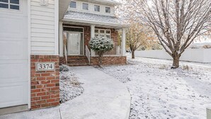 A two-story house with a brick facade and a white garage door. - 5BR I Sleeps 10, King x2, Pack n Play, Air Hockey (Fargo)