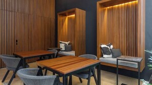 A modern interior with wooden panel walls, a sofa, and a dining table with chairs. - Ocean View • Private Terrace • Luxury Rooftop & 1 Min to Beach (Playa del Carmen)