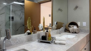 Un baño moderno con dos lavabos, un espejo grande y una zona de ducha.