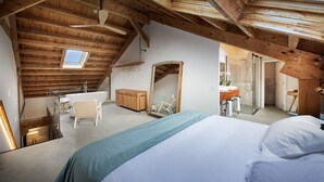 A bedroom with a skylight, a bed, a bathroom with a sink, and a mirror. - Luxury Suite Fábrica de Sensaciones in Palencia with Wi-Fi (Abarca de Campos)