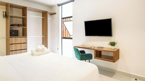 Ein modernes Schlafzimmer mit Bett, Schreibtisch mit Stuhl, Fernseher und Kleiderschrank.