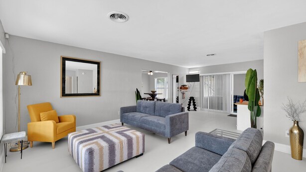 A modern living room with a sofa, armchair, ottoman, and a floor lamp. - Work, Play or Recharge:3BR Pool Home near Legoland (Winter Haven)